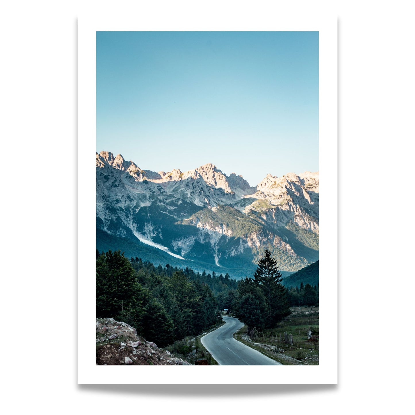 Motivet fra Valbona Valley National Park i Albania viser et majestetisk fjellandskap med høye topper som strekker seg mot en krystallklar, blå himmel. 