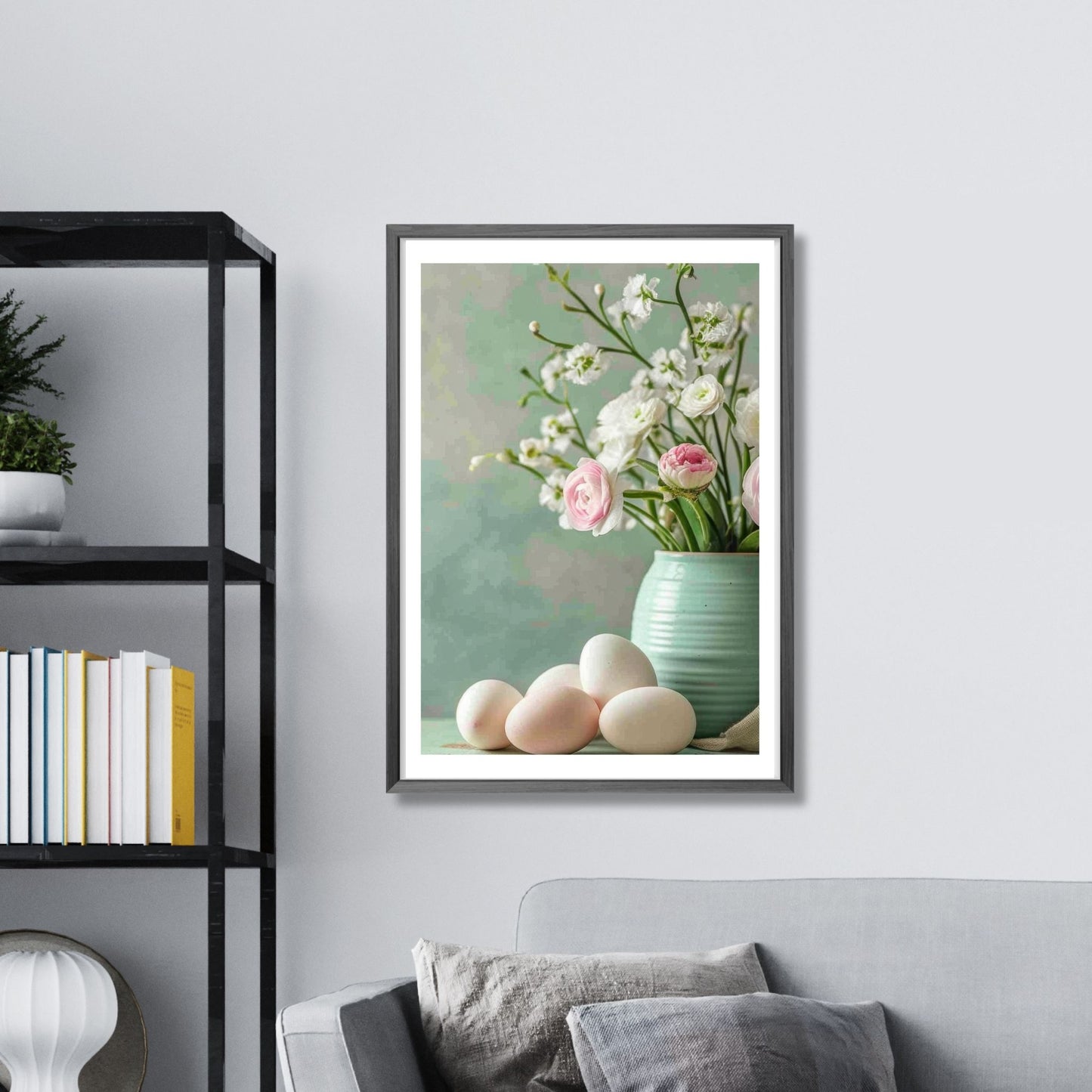 turkis vase fylt med delikate hvite og rosa blomster, perfekt supplert av flere hvite og rosa påskeegg som ligger ved siden av. Illustrasjonsfoto som viser plakat i vertikalt format i ramme over en sofa.