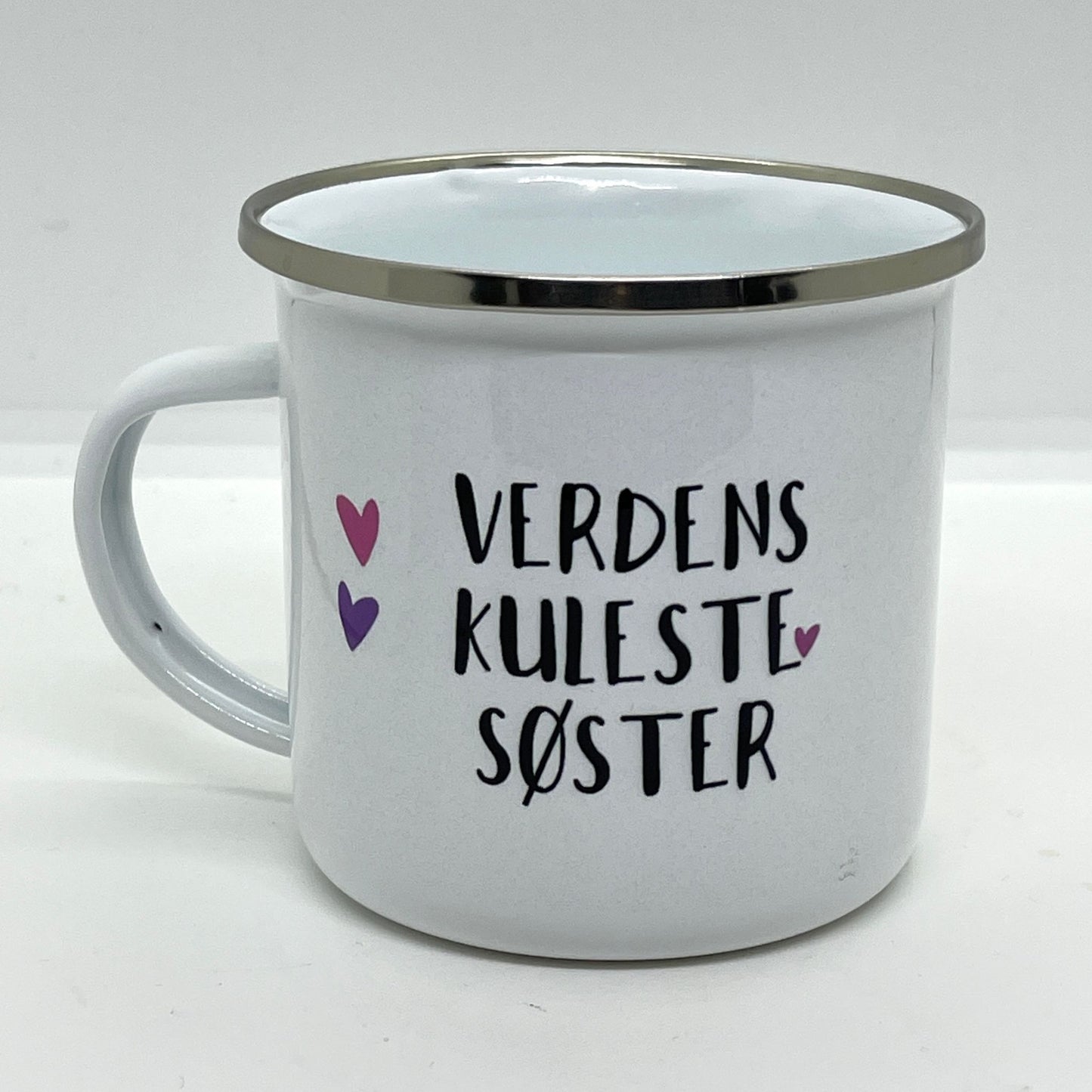 Dette lette og robuste emaljekruset er en hyllest til søsteren din! Med et søtt design som kombinerer en leken illustrasjon og teksten "Verdens Kuleste Søster", er dette kruset både funksjonelt og personlig.